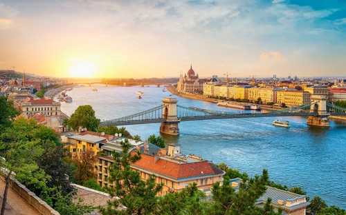 Avokattoinen kiertoajelubussi parlamenttitalolla Budapestissa